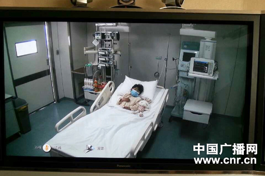 Photo taken on April 13, 2013 shows a screen showing a seven-year-old girl, who was infected with the H7N9 strain of bird flu, receiving medical treatment in the Beijing Ditan Hospital, during a press conference held by the hospital in Beijing, capital of China.