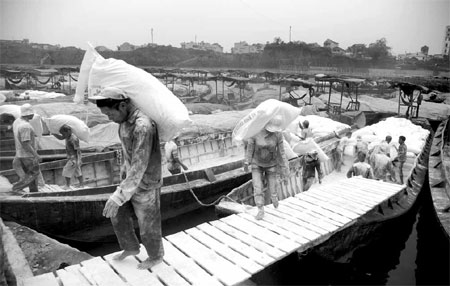 Workers unloading goods imported from Vietnam at a dock in Dongxing city, South China's Guangxi Zhuang autonomous region. Around 75 percent of respondents expect wages to increase by as much as 10 percent this year, similar to 2012, said Standard Chartered in its latest report. [China Daily]