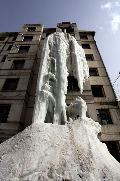An eight-meter wide and four-meter thick icicle hangs from a seventh floor apartment balcony after the owner left the tap running in Jilin city, Northeast China's Jilin province on April 13, 2013.