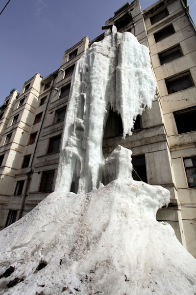 An eight-meter wide and four-meter thick icicle hangs from a seventh floor apartment balcony after the owner left the tap running in Jilin city, Northeast China's Jilin province on April 13, 2013. 