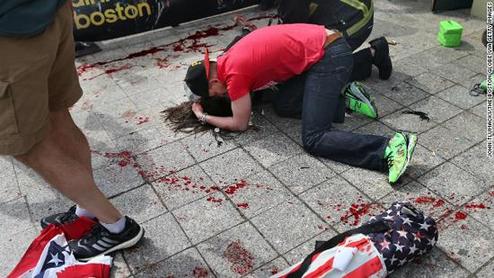 A man comforts a victim on the sidewalk at the scene of the first of two apparent bombings near the finish line of the Boston Marathon on Monday, April 15. 