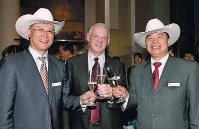 From left: CNOOC CEO Li Fanrong, Nexen CEO Kevin Reinhart and CNOOC Chairman Wang Yilin celebrate the signing of the $15.1 billion deal in Calgary. [China Daily]