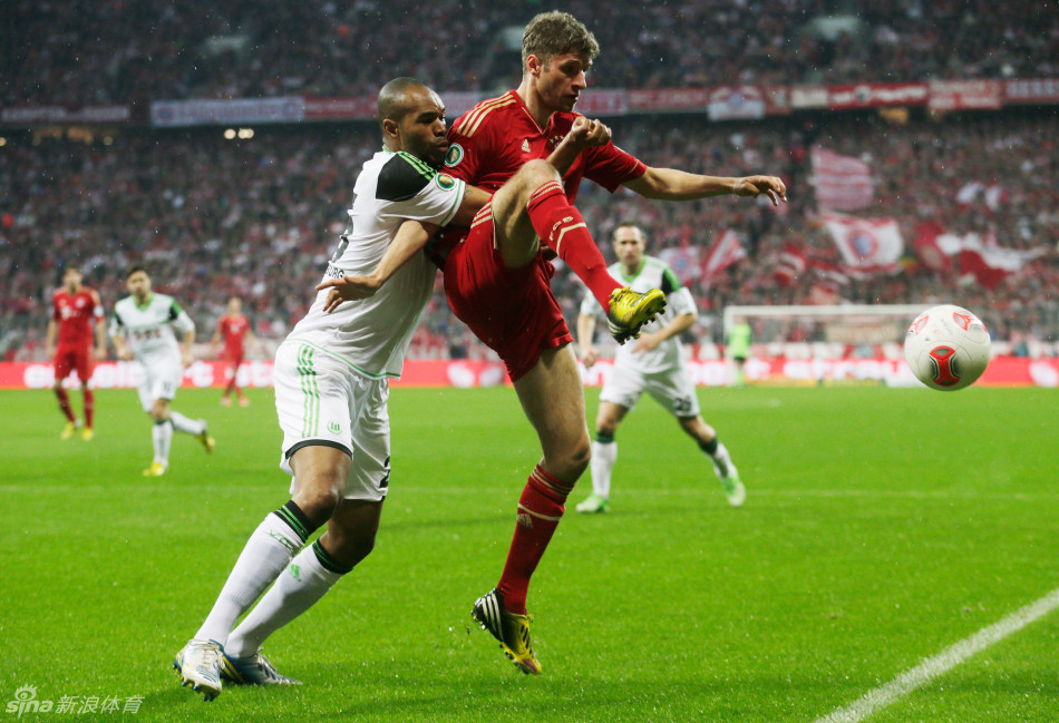 Muller holds off Naldo to control the ball.