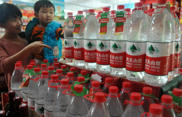 A bottled water display in a supermarket in Qionghai, Hainan province, catches a child's interest on Saturday. Meng Zhongde / for China Daily 