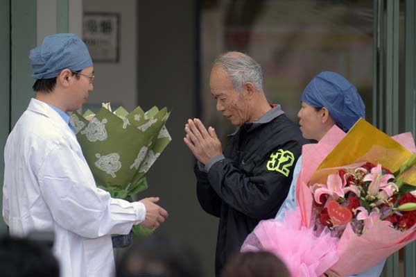 A man who has recovered from H7N9 flu thanks a medical worker before being discharged from a Shanghai hospital on Thursday. Liu Yuan / for China Daily  