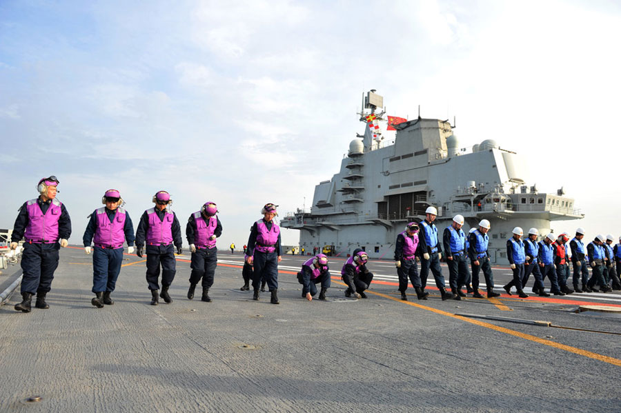 Crew members onboard China's Liaoning Aircraft Carrier inspect the dock on Thursday April 18, 2013. [Photo/CFP]