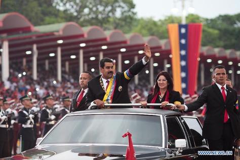 Venezuelan President Nicolas Maduro (2nd L) and his wife Cilia Flores (2nd R) take part in a military parade to commemorate the 203rd anniversary of the independence, in the city of Caracas, capital of Venezuela, on April 19, 2013. [Xinhua]
