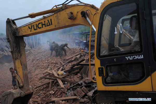 Rescuers conduct rescue work in quake-hit Qingren Township, Lushan County, Ya'an City, southwest China's Sichuan Province, April 20, 2013. [Yu Ping/Xinhua]