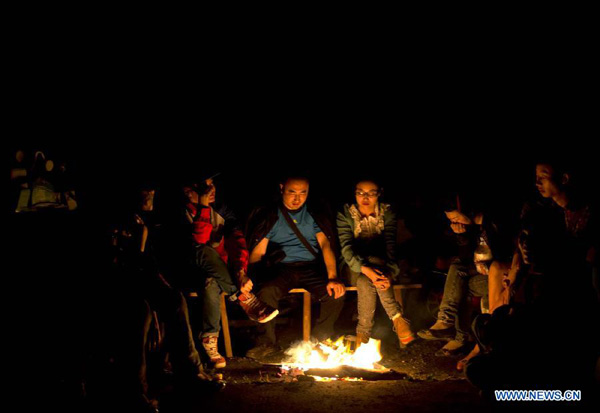 Villagers lit fire to warm themselves in Yuxi Village in severely-hit Baosheng Township of the quake-hit Lushan County, Ya'an City, southwest China's Sichuan Province, April 20, 2013. [Fei Maohua/Xinhua]