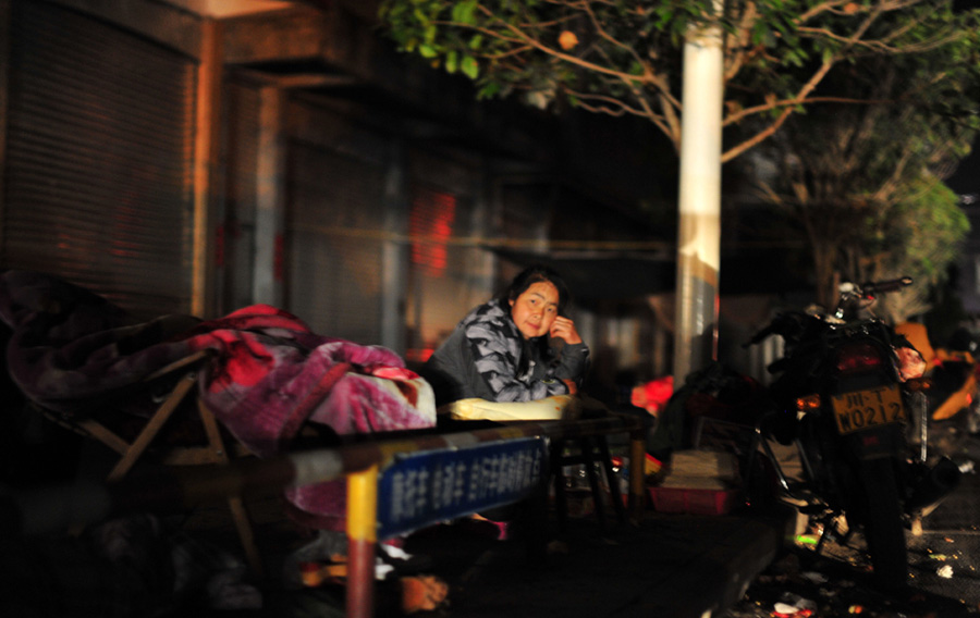 A villager has a rest along the street in Lushan County, Ya'an City, southwest China's Sichuan Province, April 21. A 7-magnitude earthquake hit the county at 8:02 a.m. Saturday Beijing Time, according to the China Earthquake Networks Center (CENC). [Xiao Yijiu/Xinhua]