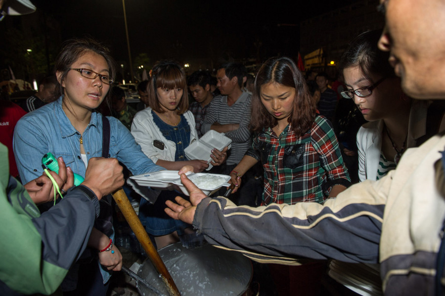 Volunteers provide hot meals for villagers and rescuers in Lushan County, Ya'an City, southwest China's Sichuan Province, April 21. A 7-magnitude earthquake hit the county at 8:02 a.m. Saturday Beijing Time, according to the China Earthquake Networks Center (CENC). [Chen Cheng/Xinhua]