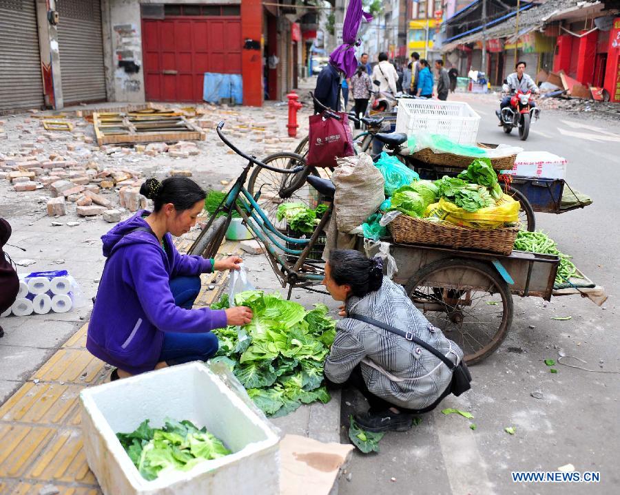 A vegetable vendor resumes her business in Lushan County of Ya'an City, southwest China's Sichuan Province, April 21, 2013. Locals tried to get their lives back to normal soon as the 7.0-magnitude earthquake hit Lushan County of Sichuan Province on Saturday morning, leaving 180 people dead and 11,227 others injured so far. [Xiao Yijiu/Xinhua]