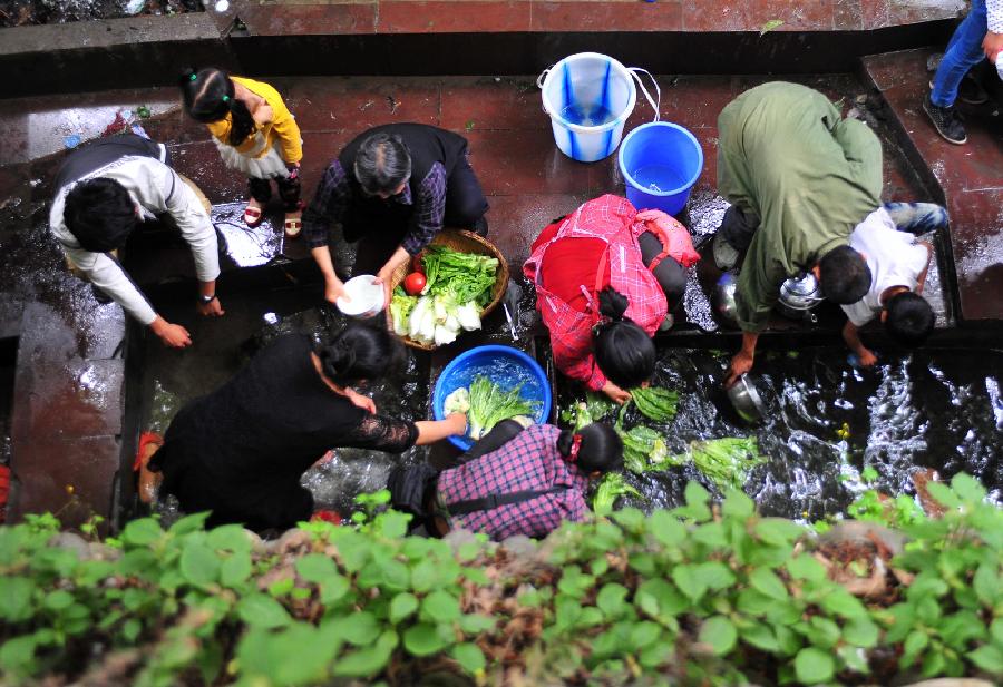Residents wash vegetables at a well in Lushan County of Ya'an City, southwest China's Sichuan Province, April 21, 2013. Locals tried to get their lives back to normal soon as the 7.0-magnitude earthquake hit Lushan County of Sichuan Province on Saturday morning, leaving 180 people dead and 11,227 others injured so far. [Xiao Yijiu/Xinhua]