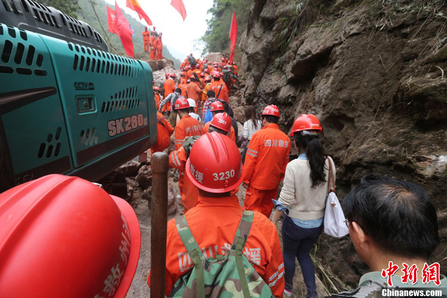 Rescuers and reporters rush to Baoxing County, an isolated county in southwest China's Sichuan Province hit by Saturday's strong earthquake, on April 21. The first rescuers have reached there Sunday morning. [Chinanews.com]