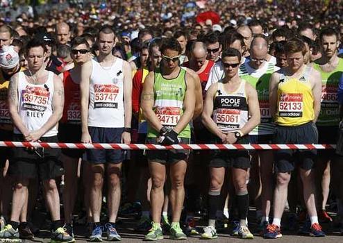 Silence: London runners pause to remember the terrible events in Boston, where bombs killed three people and injured more than 100. 