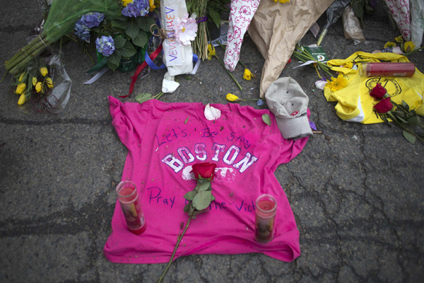 Well-wishers leave a shirt at a make-shift memorial on Boylston Street a day after two explosions hit the Boston Marathon in Boston, Massachusetts April 16, 2013. [Photo/China Daily]     