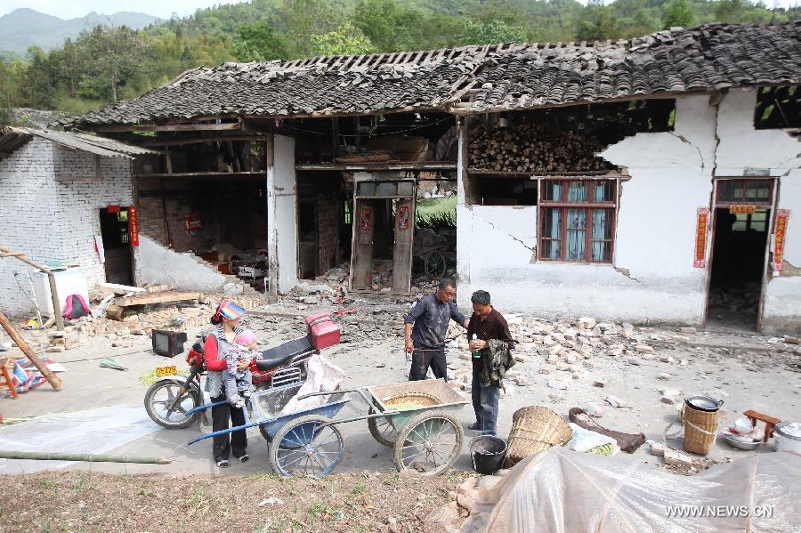Residents stand outside of their damaged houses after a 7.0-magnitude earthquake in Longmen Township, Lushan County, Ya'an City of southwest China's Sichuan Province, April 20, 2013.[Photo/Xinhua]