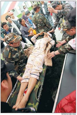 An injured resident is moved to a temporary shelter at Lingguan middle school in Baoxing county. [Photo/Xinhua]