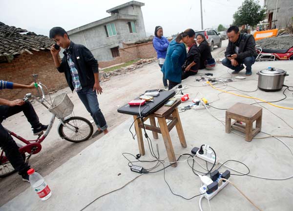 Cellphones and a laptop being recharged at an electric supply station in Lushan county, Sichuan province, on Sunday. [Photo/China Daily]