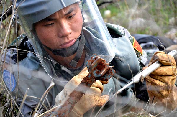 A Chinese peacekeeper tries to defuse a bomb.[Photo/China Daily] 