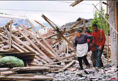 Villagers survey the remains of their houses in Wuxing. 
