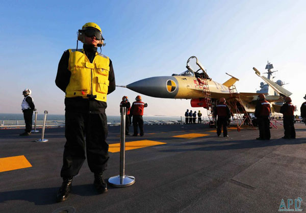 Crew members stand near a fighter jet on China's first aircraft carrier 'Liaoning' in this undated photo. [File Photo: cn.apdnews.com]