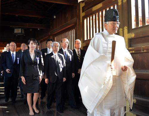 A Shinto priest (R) leads a group of Japanese lawmakers to offer prayers for the country's war dead at the controversial Yasukuni Shrine in Tokyo on the occasion of the shrine's spring festival, on April 23, 2013.  [Xinhua/AFP]