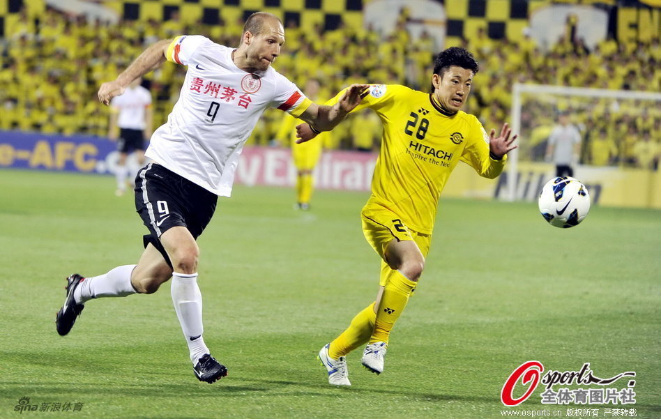 Muslimovic and Ryoichi Kurisawa run for the ball.