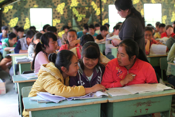 Ninth-grade students of Longmen Middle School in a makeshift classroom in Lushan, Sichuan province, on Wednesday. [Photo/China Daily]
