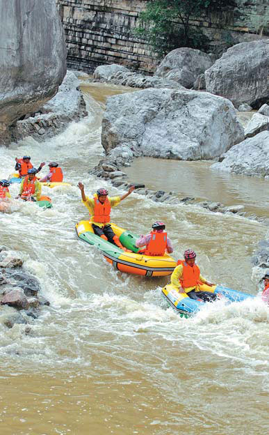 Tourists enjoy whitewater rafting at Chaotianhou in Xingshan county, Hubei province, on Tuesday. The stretch of river is 5 km long and descends 100 meters from start to finish. [China Daily]