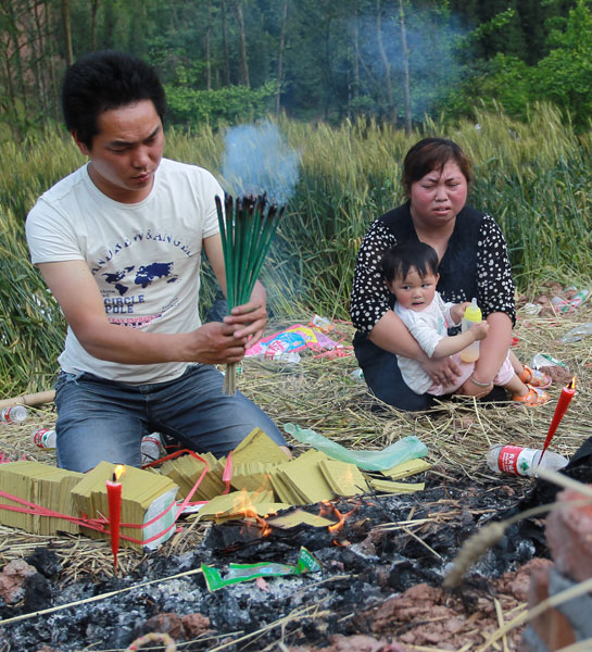 Shu Wei, his wife Yang Xiaoli and younger daughter mourn the family’s 5-year-old elder daughter who was killed in last Saturday’s earthquake in Lushan county, Sichuan province.[Photo/China Daily]