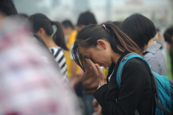 Students lower their heads during a silent tribute to the victims of Lushan April 20 earthquake, in Lushan Middle School, Ya'an city, Southwest China's Sichuan province on April 27, 2013. [Photo/Xinhua] 