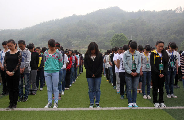 Students lower their heads during a silent tribute to the victims of Lushan April 20 earthquake, in Lushan Middle School, Ya'an city, Southwest China's Sichuan province on April 27, 2013. [Photo/Xinhua] 
