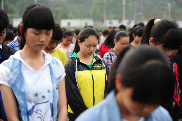  Students lower their heads during a silent tribute to the victims of Lushan April 20 earthquake, in Lushan Middle School, Ya'an city, Southwest China's Sichuan province on April 27, 2013. [Photo/Xinhua]