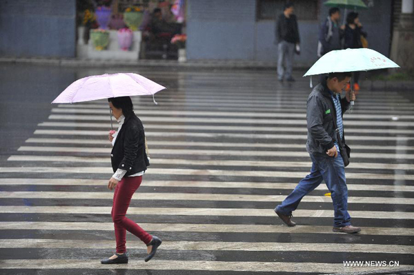 People walk in rain near Tingjin Road in Ya'an City, southwest China's Sichuan Province, April 29, 2013. [Xinhua/Lu Peng]