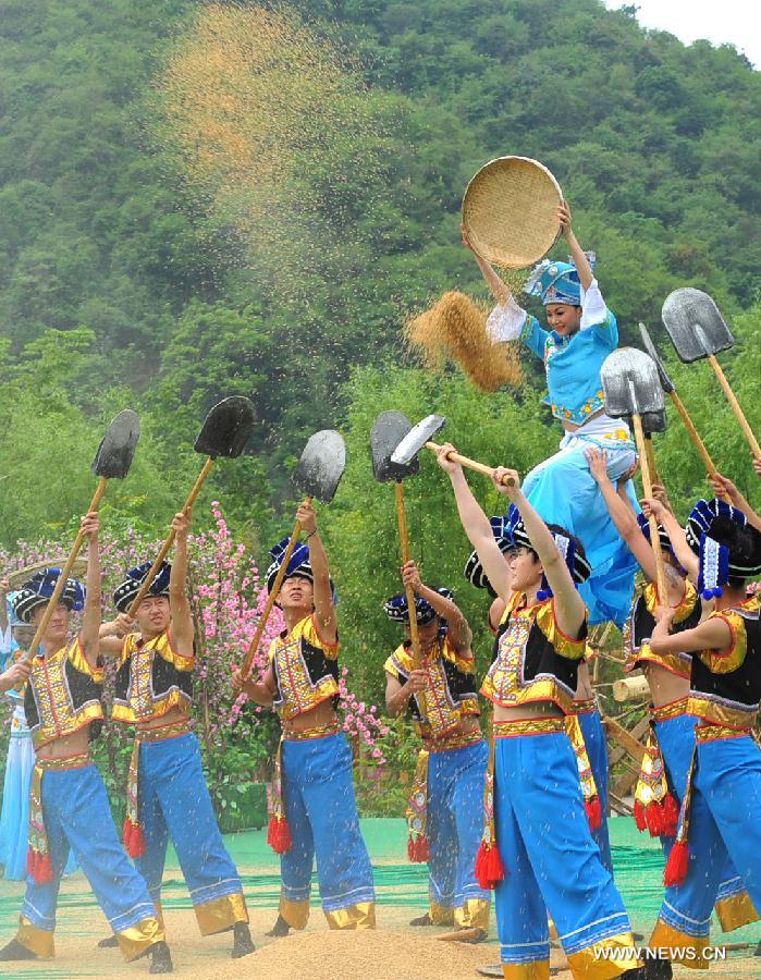 Villagers of Zhuang ethnic group stage a harvest dance during a performance held for tourists in Bamei Village, Guangnan County, southwest China's Yunnan Province, April 30, 2013. The county arranged the performance in the hope of displaying local cultural and landscape, and drawing tourists during the three-day May Day holidays. (Xinhua/Chen Haining) 