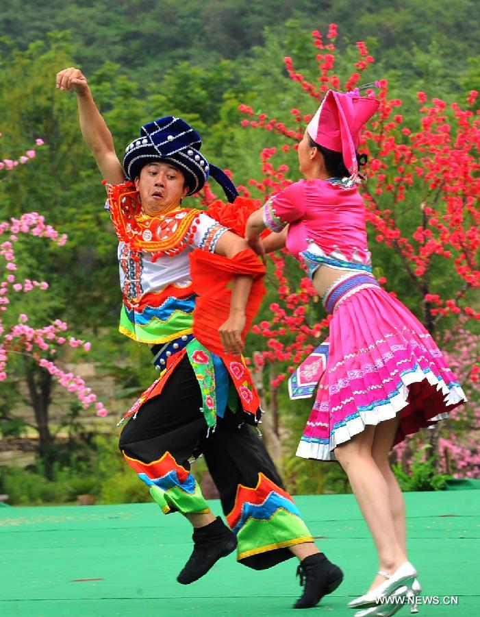 Villagers of Zhuang ethnic group stage a performance held for tourists in Bamei Village, Guangnan County, southwest China's Yunnan Province, April 30, 2013. The county arranged the performance in the hope of displaying local cultural and landscape, and drawing tourists during the three-day May Day holidays. (Xinhua/Chen Haining) 