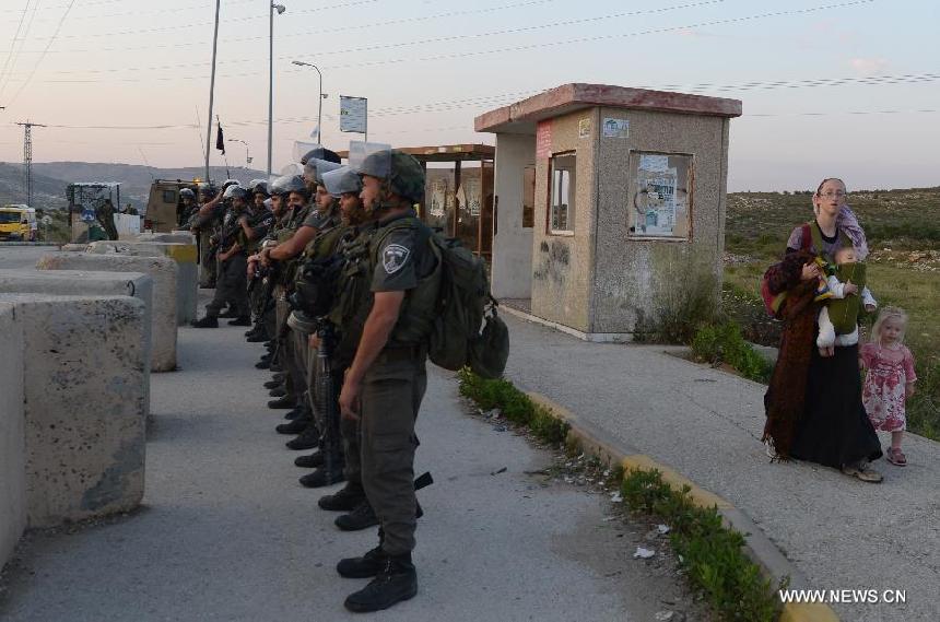 Israeli security forces guard to prevent possible clashes between Israeli settlers and Palestinians at Tapuach, a major junction in the northern West Bank in the evening of April 30, 2013, after a Jewish settler was stabbed to death by a Palestinian man here in the morning. Hundreds of Jewish settlers protested at the Tapuach Junction, where Jewish settler Eviatar Borovsky was stabbed to death Tuesday morning.(Xinhua/Yin Dongxun)