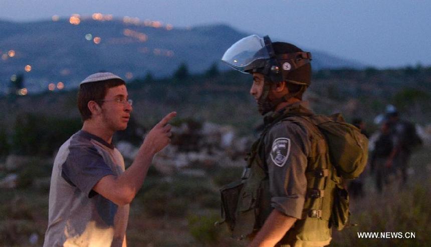 Jewish settlers protest at Tapuach, a major junction in the northern West Bank in the evening of April 30, 2013, after a Jewish settler was stabbed to death by a Palestinian man here in the morning. Hundreds of Jewish settlers protested at the Tapuach Junction, where Jewish settler Eviatar Borovsky was stabbed to death Tuesday morning.(Xinhua/Yin Dongxun)