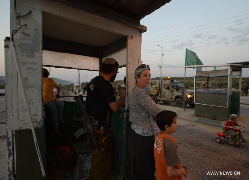 Jewish settlers protest at Tapuach, a major junction in the northern West Bank in the evening of April 30, 2013, after a Jewish settler was stabbed to death by a Palestinian man here in the morning. Hundreds of Jewish settlers protested at the Tapuach Junction, where Jewish settler Eviatar Borovsky was stabbed to death Tuesday morning. (Xinhua/Yin Dongxun)