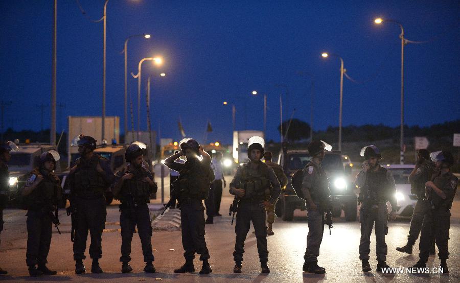 Israeli security forces guard to prevent possible clashes between Israeli settlers and Palestinians at Tapuach, a major junction in the northern West Bank in the evening of April 30, 2013, after a Jewish settler was stabbed to death by a Palestinian man here in the morning. Hundreds of Jewish settlers protested at the Tapuach Junction, where Jewish settler Eviatar Borovsky was stabbed to death Tuesday morning.(Xinhua/Yin Dongxun)