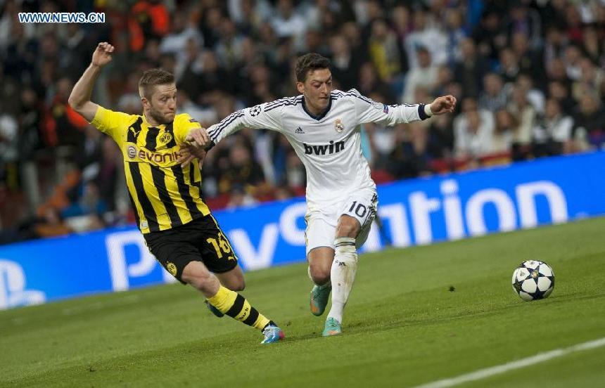 Real Madrid&apos;s Mesut Ozil (R) vies with Borussian Dortmund&apos;s Jakub Blaszczykowski during the UEFA Champions League semi-final second leg football match in Madrid, capital of Spain, April 30, 2013. Borussia Dortmund qualified for the Champions League final, beating Real Madrid 4-3 on aggregate despite a 2-0 loss Tuesday. (Xinhua/Xie Haining)