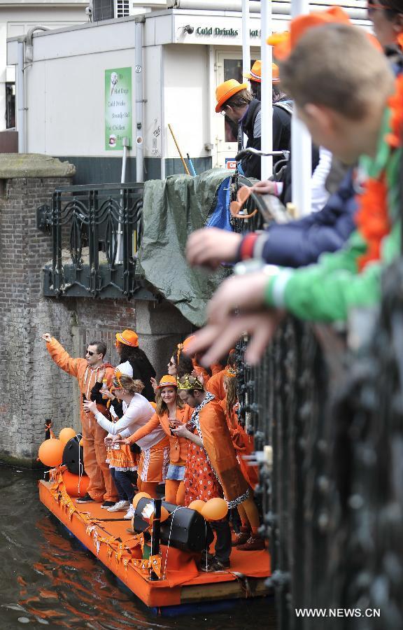 People celebrate the inauguration of the new King of the Netherlands Willem-Alexander in Amsterdam, the Netherlands, April 30, 2013. Following the abdication of Queen Beatrix, the new King of the Netherlands Willem-Alexander was officially inaugurated on Tuesday. (Xinhua/Ye Pingfan) 