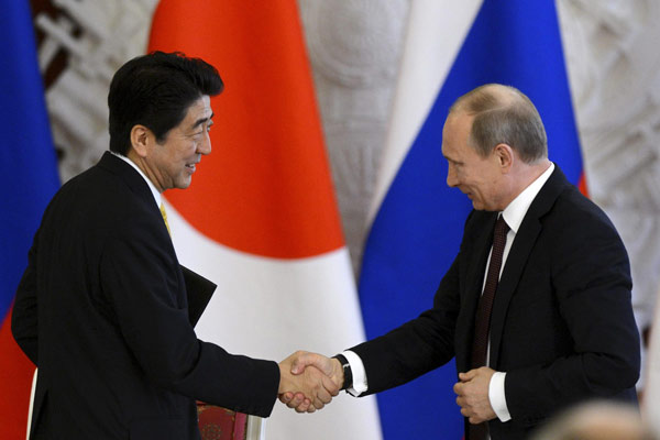 Russia's President Vladimir Putin (R) shakes hands with Japan's Prime Minister Shinzo Abe during a signing ceremony at the Kremlin in Moscow April 29, 2013. [China Daily/Agencies]