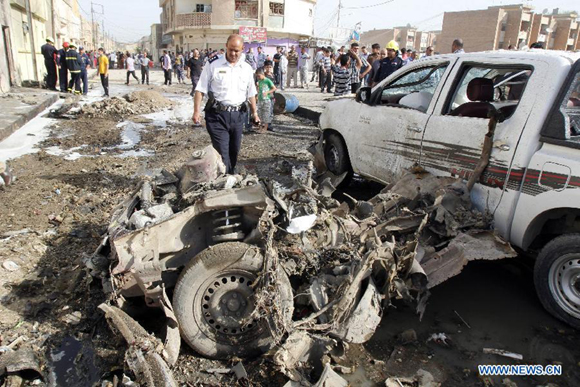 Rescuers look over the site where a car bomb attack happened in Kirkuk, a northern city of Iraq, April 15, 2013. At least 16 people died and 100 people injured in several bomb attacks that happend in different places of Iraq on April 15.