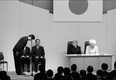 安倍在仪式上向日本天皇鞠躬。