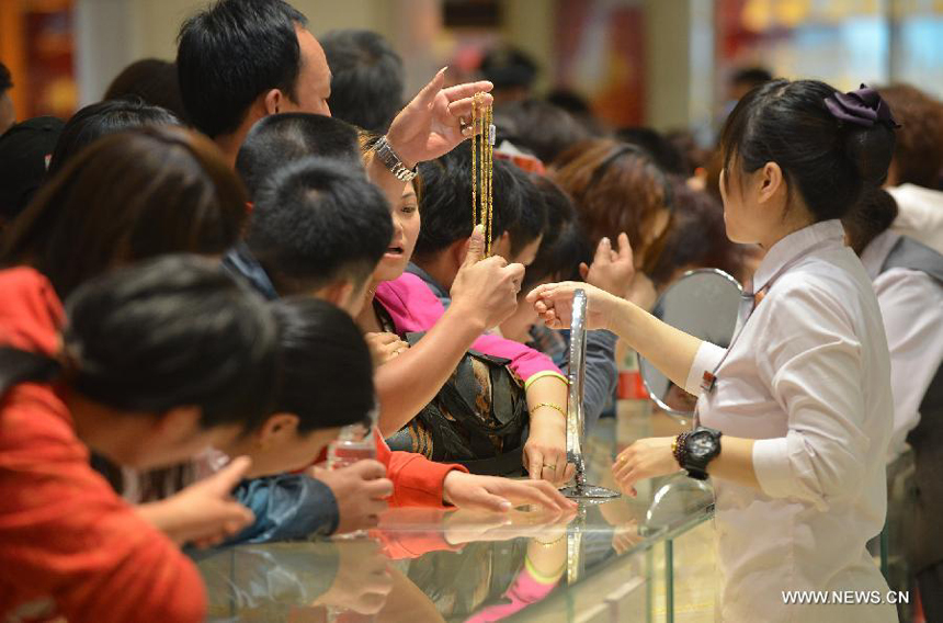 Customers select gold accessories in Caibai, one of best-known gold retailers in Beijing, China, May 2, 2013. Sales of gold reached 200 million RMB (32.44 million U.S. dollars), up 30 percent year on year during the three-day May Day holiday at Caibai due to recent abrupt price drop for the precious metal. 