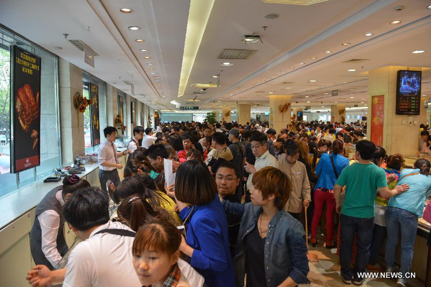 Customers select gold accessories in Caibai, one of best-known gold retailers in Beijing, China, May 2, 2013. Sales of gold reached 200 million RMB (32.44 million U.S. dollars), up 30 percent year on year during the three-day May Day holiday at Caibai due to recent abrupt price drop for the precious metal.