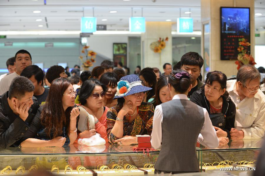 Customers select gold accessories in Caibai, one of best-known gold retailers in Beijing, China, May 2, 2013. Sales of gold reached 200 million RMB (32.44 million U.S. dollars), up 30 percent year on year during the three-day May Day holiday at Caibai due to recent abrupt price drop for the precious metal.