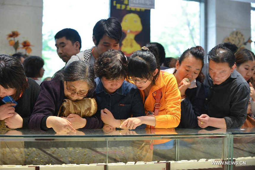 Customers select gold accessories in Caibai, one of best-known gold retailers in Beijing, China, May 2, 2013. Sales of gold reached 200 million RMB (32.44 million U.S. dollars), up 30 percent year on year during the three-day May Day holiday at Caibai due to recent abrupt price drop for the precious metal.